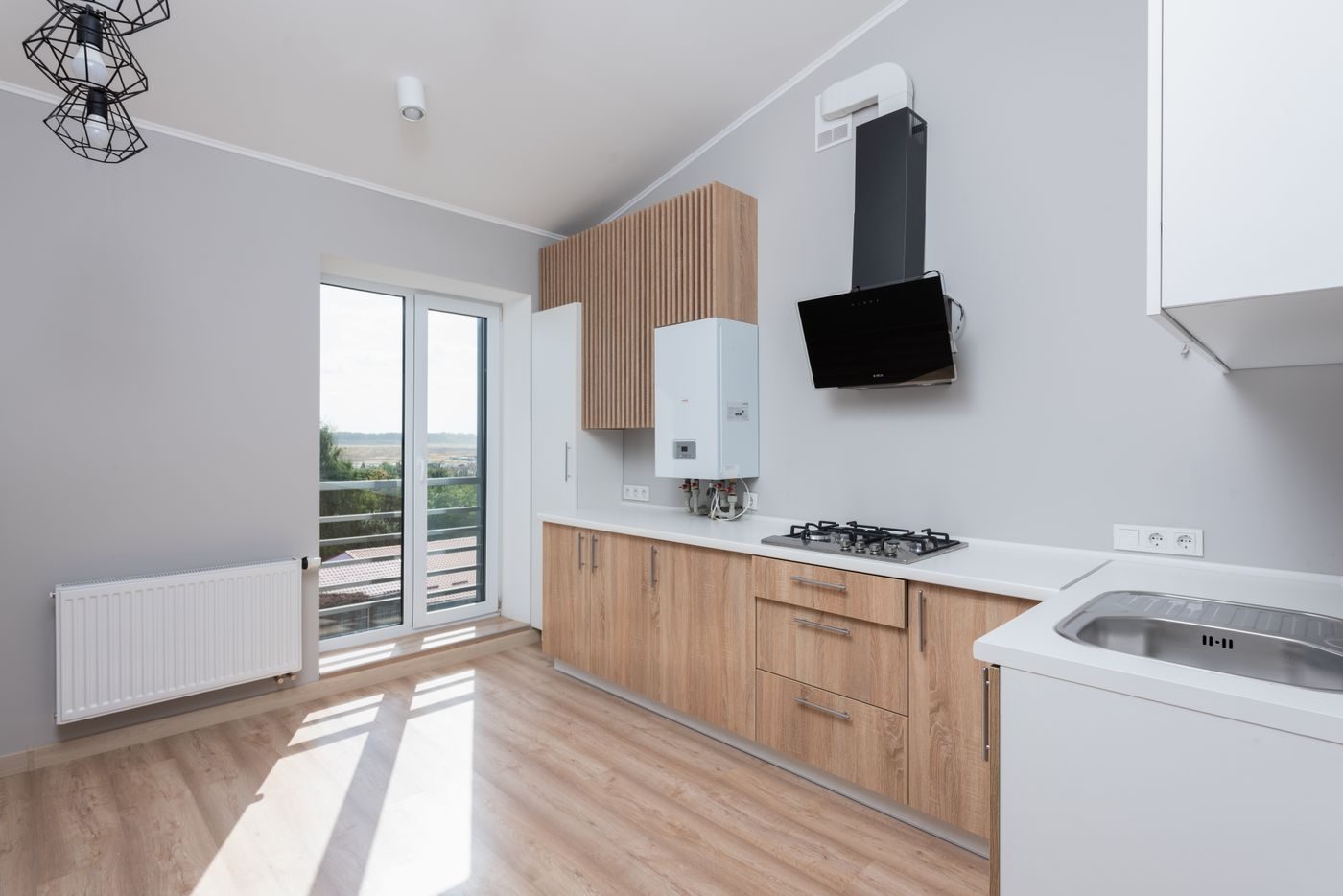 Bright kitchen with a new white combi boiler on the wall beside the hob, cool daylight