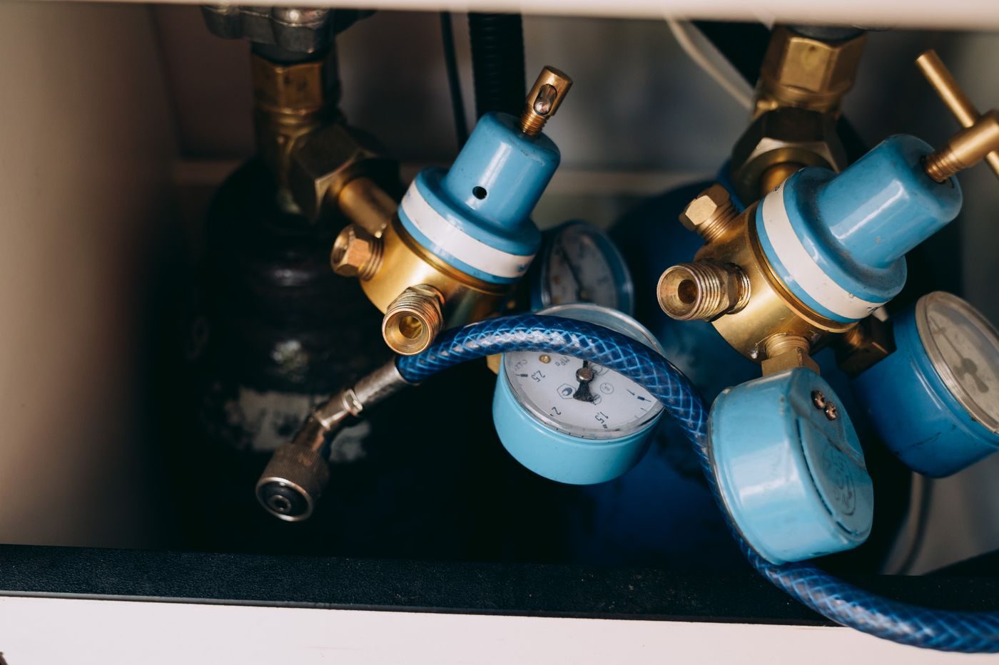 Gas pressure regulators with dial gauges and a braided hose